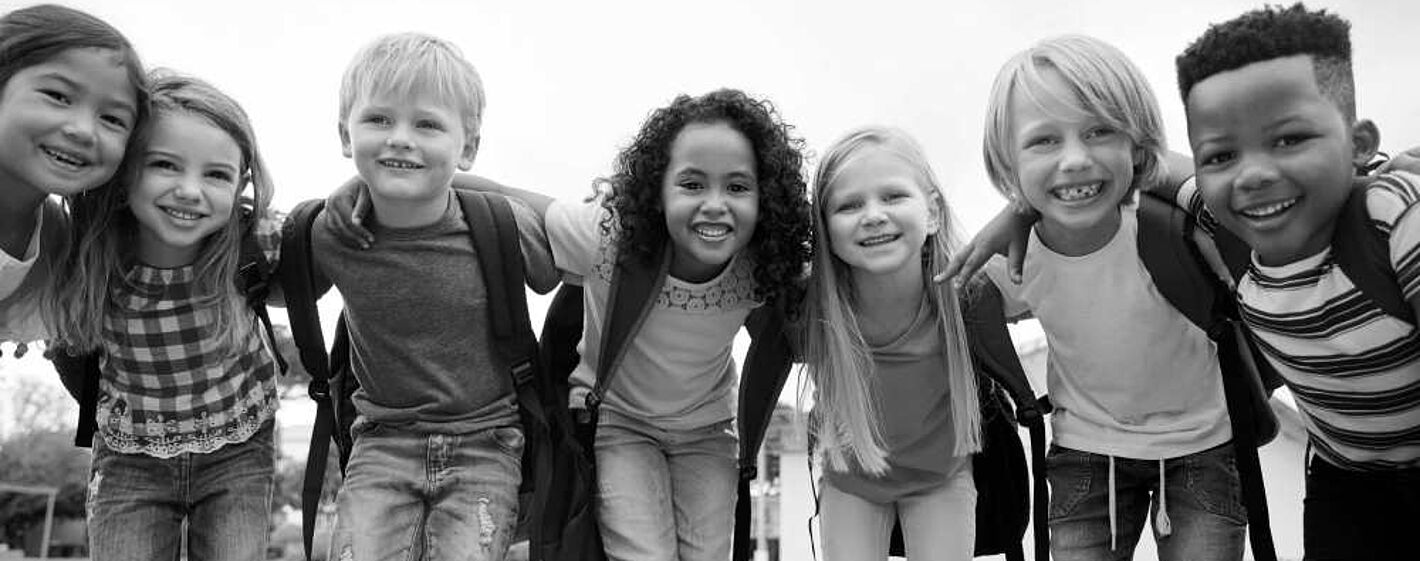 Kinder stehen in Reihe zusammen und lachen